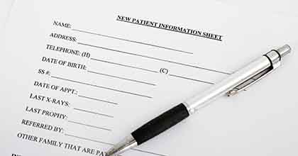 new patient dental forms with a pen on top of them