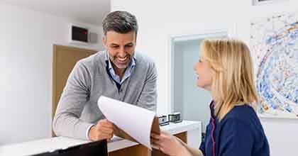 a front desk staff explaining dental insurance coverage to a patient