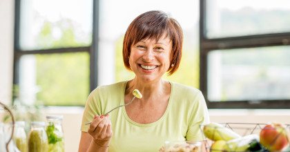 Woman smiling while eating healthy meal at home