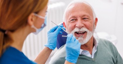 Mature man smiling during dental checkup in New Bedford